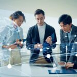 Team beim Business-Meeting, vernetzt durch digitale Technologien – ideal für Unternehmen, die skalierbare IT-Lösungen und Keycloak Hosting nutzen möchten.