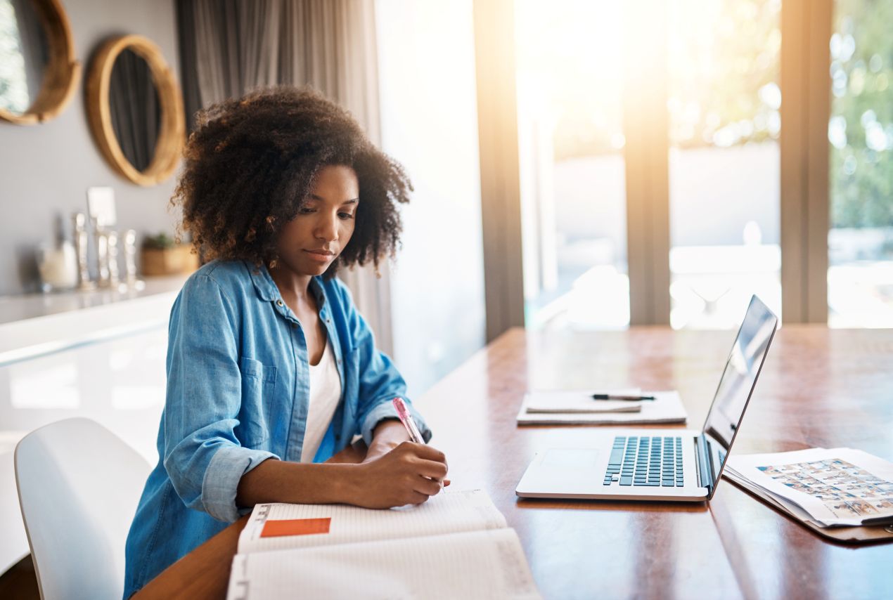 Junge Frau lernt mit Laptop und Notizen. Welche Ghostwriter Masterarbeit Erfahrungen gibt es zu Qualität und Legalität?