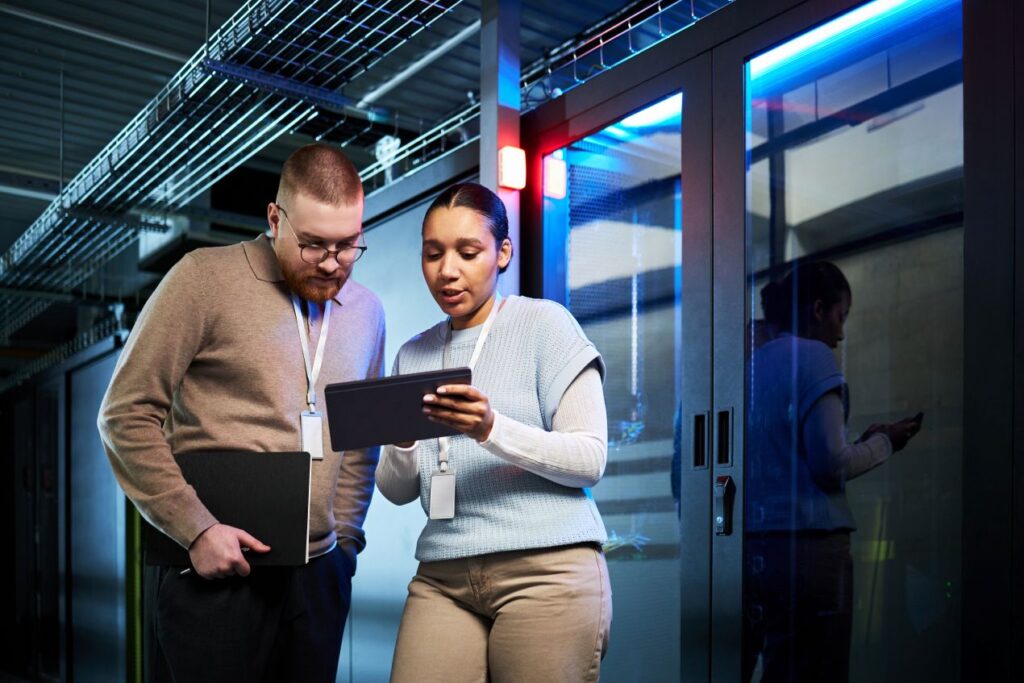 Zwei IT-Fachleute mit Tablet vor Serverraum besprechen Upgrade mit SFP Modul