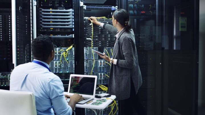Techniker verbinden Glasfaserkabel mit SFP Modul Switch bei laufender Netzwerkumgebung