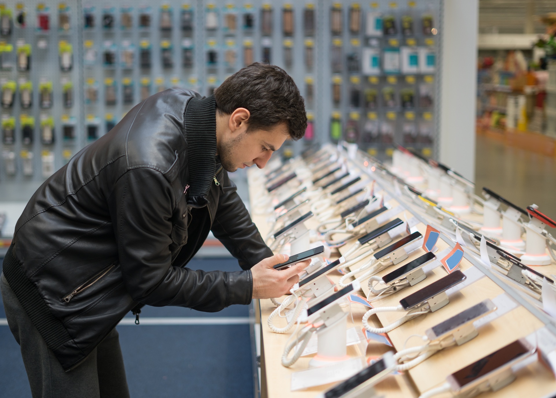 Kunde testet Smartphones in einem Elektronik-Geschäft | Handy Reparatur Salzburg